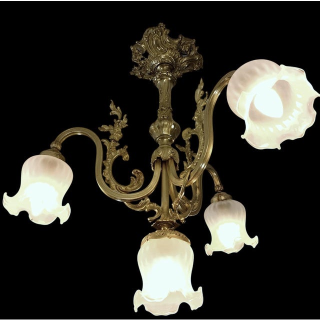 An elegant french art nouveau style bronze / brass chandelier. the fixture features three beautifully curved ornate arms...