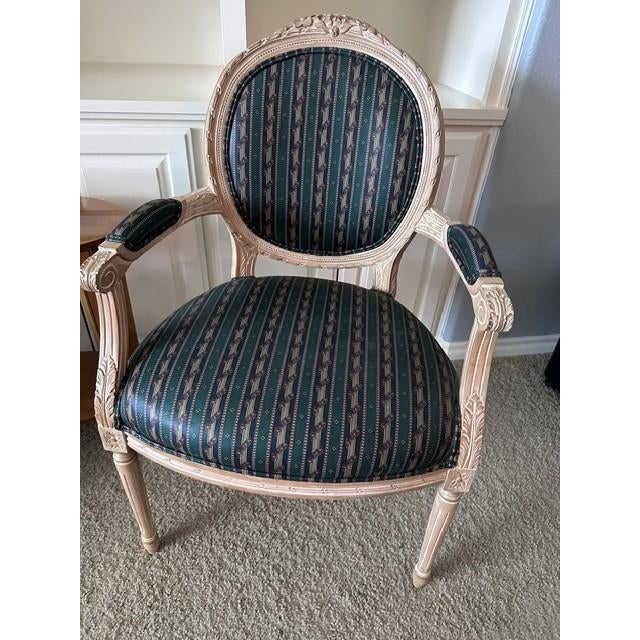 These elegant armchairs feature a classic French Louis XVI style design characterized by its iconic oval medallion back...