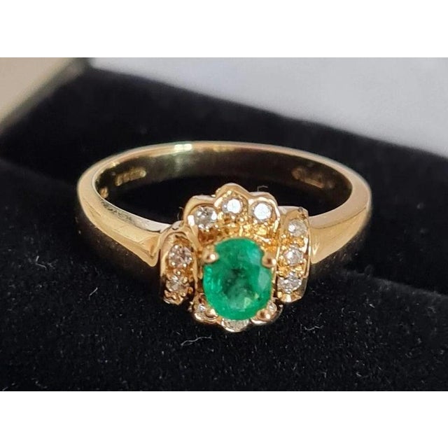 An elegant vintage british dress ring by ruk, crafted in solid 18-carat yellow gold and set with a central emerald...