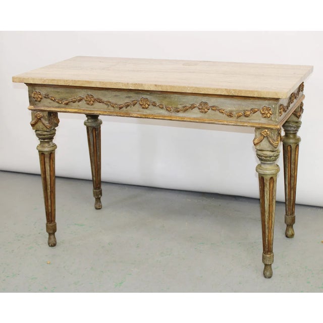 An elegant and finely carved 18th century Italian console table, richly paint and gilt decorated, embodying the refined...