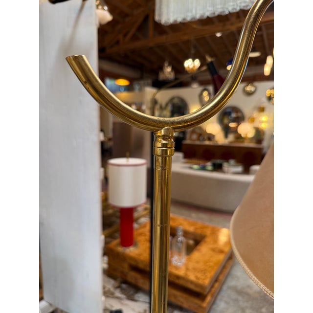 Elegant Italian floor lamp featuring a polished brass frame, sculptural curved arm, and faceted pedestal base. The height...