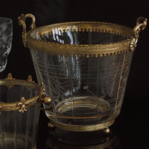 Glass bowl with floral cut-glass decoration, gold-colored metal rim, and side handles. Design origin: New item,...