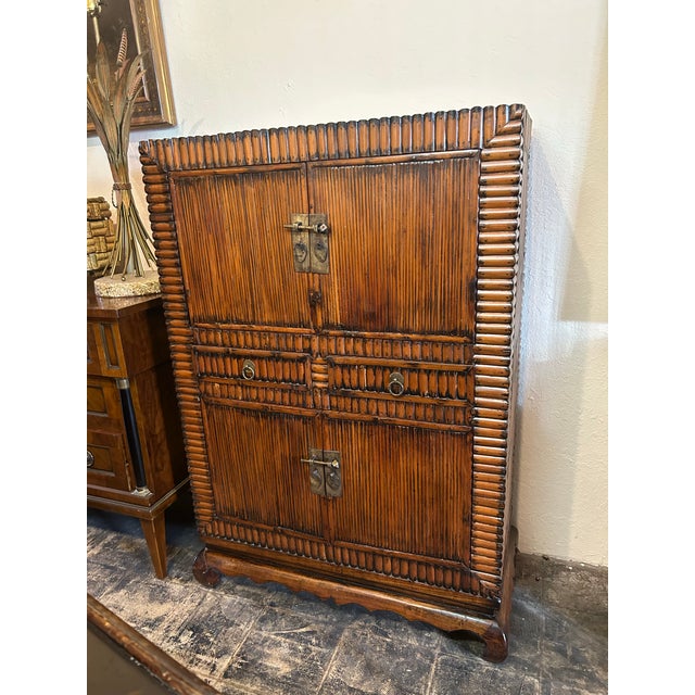 Handsome Antique Chinese cabinet crafted in bamboo and Rattan with four doors and two drawers on bracket feet.