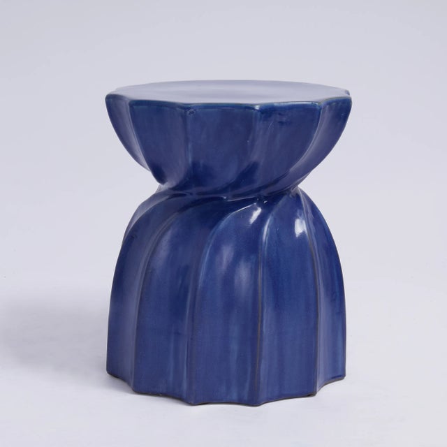 Striking pair of mid century drink stands or occasional tables crafted in redware or earthenware in a twelve point pleated...