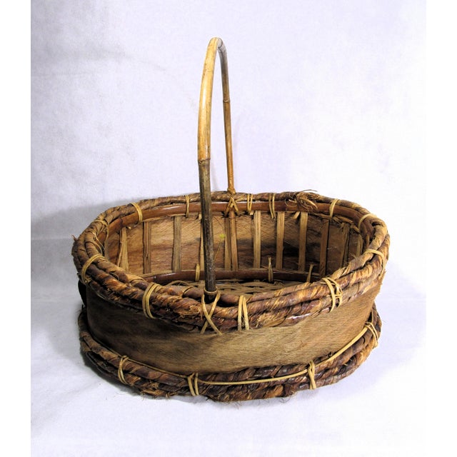 This is a rustic, hand made, oval wicker + wood shaving basket, featuring a vertical single swing handle. It has bound rim...