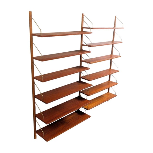 Beautiful "Royal System" wall shelf by Poul Cadovius from the 1960s. The shelving system consists of three wall rails and...