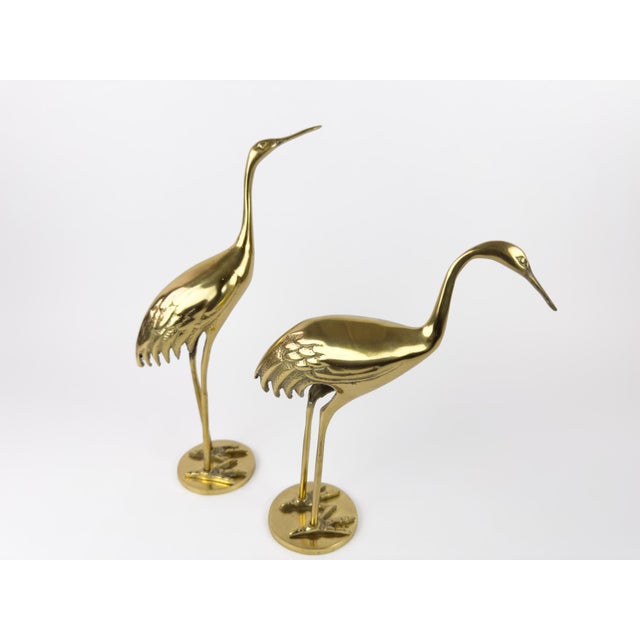 A refined pair of mid-century brass heron sculptures produced by Gilde Handwerk, Germany, circa 1960s. Cast in solid...