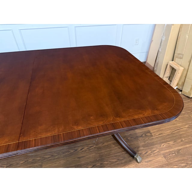 This is a classic traditional banded mahogany dining table by Leighton Hall. It features an understated field of cathedral...