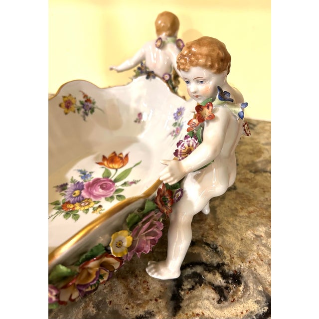 This antique, Schierholz Plaue, porcelain centerpiece bowl, with cherubs and floral decorations, was produced by...