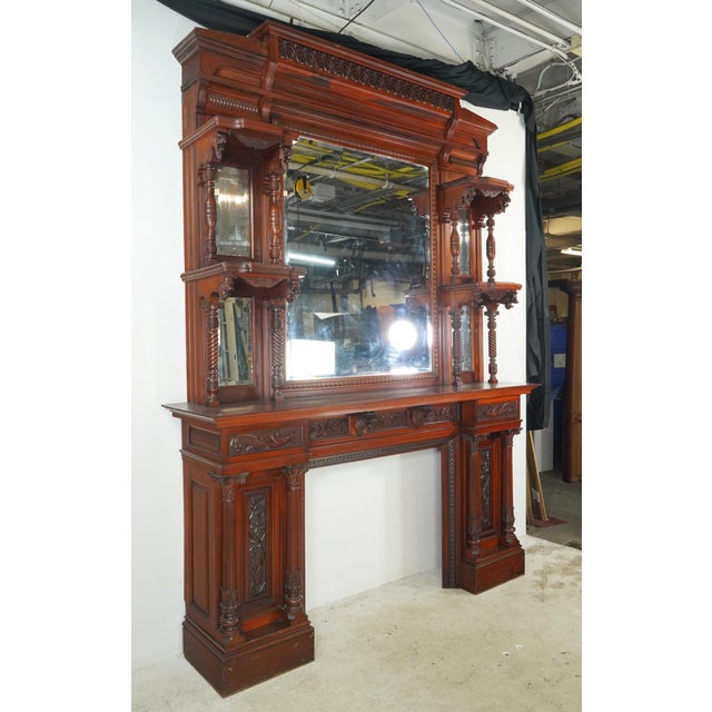 Antique Victorian monumental fireplace mantel made of mahogany in a dark stain with an upper and lower section. The upper...