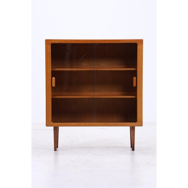 Vintage display cabinet by CFC Silkeborg with a generous glass front and clean mid-century design. The three glass shelves...