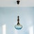 Vintage Mid-Century Modern pendant light featuring a beautifully turned wooden stem in a warm teak finish, accented with...