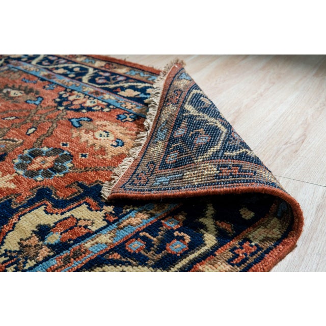 A hand-knotted wool rug, made in India and measuring 6' x 9'. Floral drawing carried across the field inside a traditional...