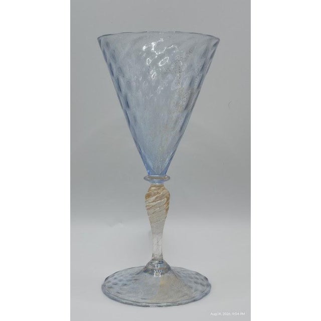 Elegant vintage Venetian Murano hand-blown wine goblet featuring a luminous ice-blue conical bowl, shimmering gold...
