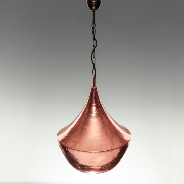 This item is a hand-hammered copper pendant light with an onion-shaped “onion dome” body, an open lower light outlet, a...