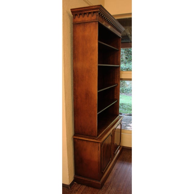 Mid-20th century Chippendale style bookcase cabinet, English. Open bookcase with four adjustable shelves over pair of...