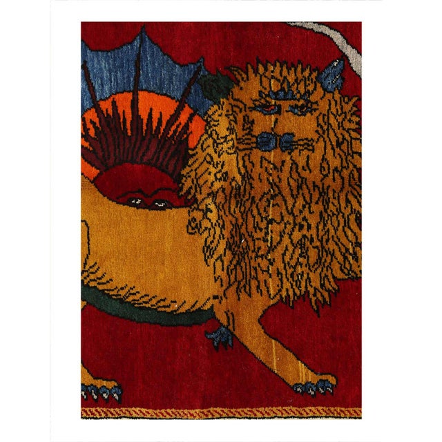 A modern small throw rug handmade during the 21st century with a pictorial design of a male lion in red-over a multi color...