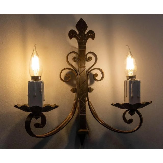 French wall light lantern or sconce, iron and wood. Motifs on the iron typical of the 60's. The fleur-de-lys at the top of...