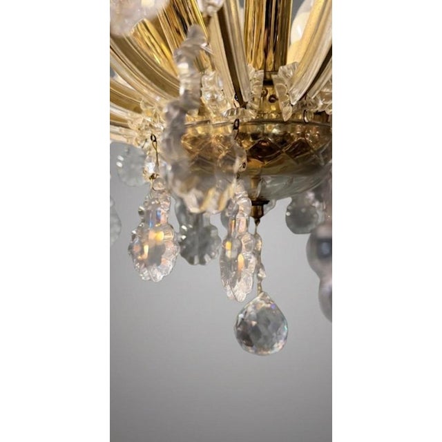 A stunning semi-flush Marie Theresa chandelier featuring a rich brass frame decorated with shimmering cut-crystal glass...