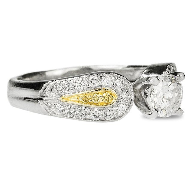 Platinum & 18k Ring with 1 round brilliant diamond weighing approximately 0.65 carats and 26 round brilliant diamonds...