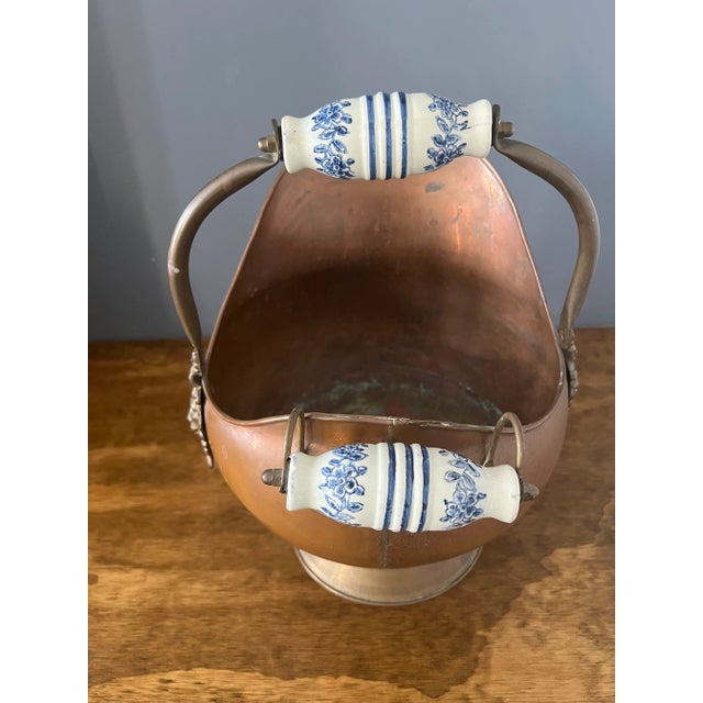 This antique copper coal scuttle was first created in England, circa 1880. Built of copper with an intricate brass. Could...
