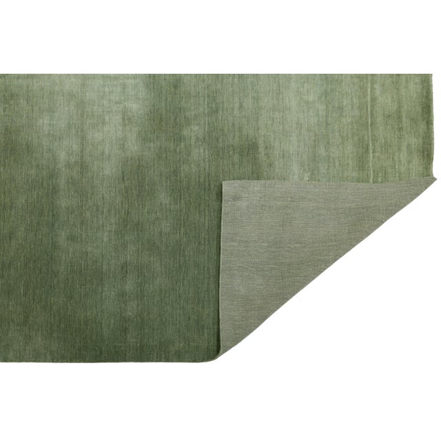 Discover our stunning handcrafted Gabbeh-style wool rug, showcasing a rich Emerald Moss green design. Proudly part of our...