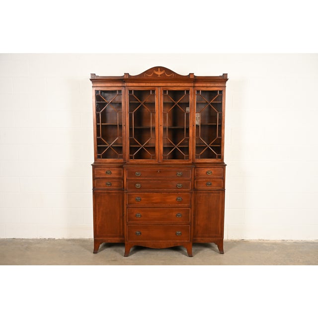 A beautiful Georgian or Federal style breakfront bookcase cabinet with drop front secretary desk In the manner of Baker...