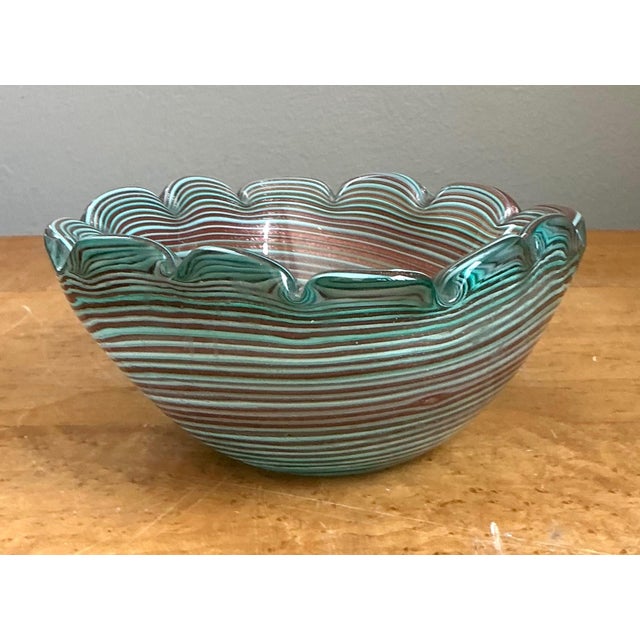 This vintage Murano art glass bowl beautifully reflects the exceptional craftsmanship and artistic innovation of renowned...