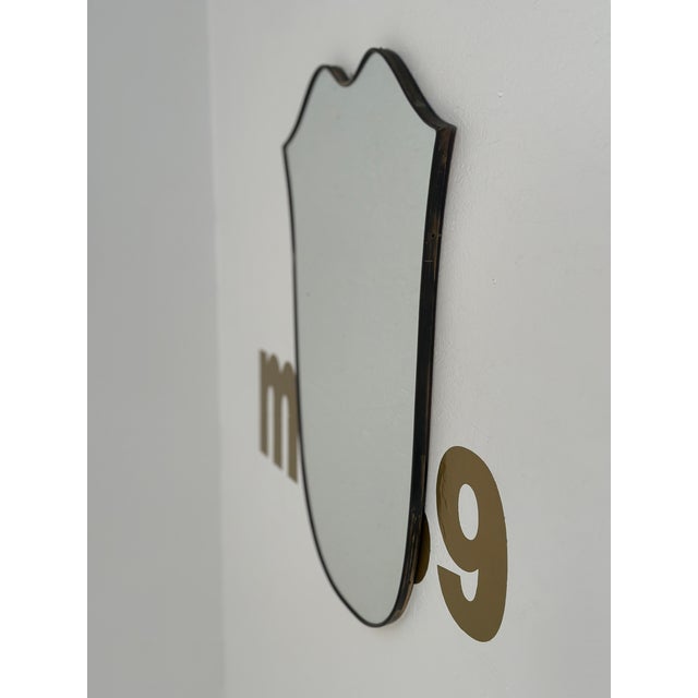 An alluring vintage Italian curvilinear brass wall mirror from the 1980s, showcasing distinctive design and craftsmanship,...