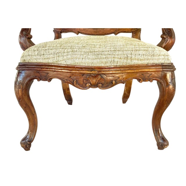 A Large Rare Pair of Venetian Rococo Carved Walnut Armchairs. Each chair features a beautifully shaped crest rail adorned...