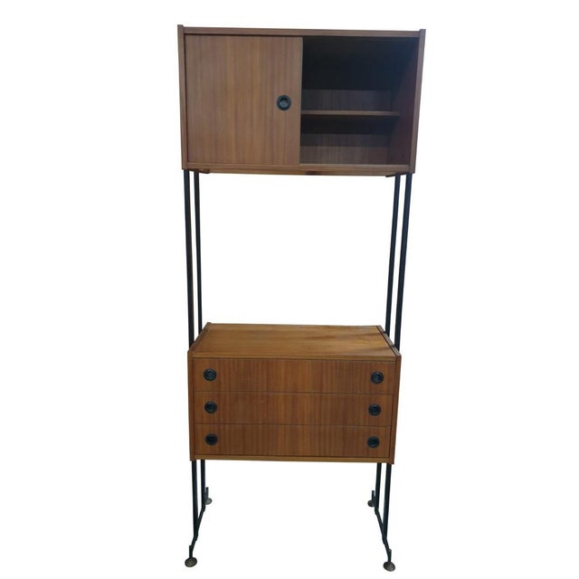 Elegant Swedish Mid-Century design unit, featuring a black lacquered metal frame with brass feet, and teak modules with...