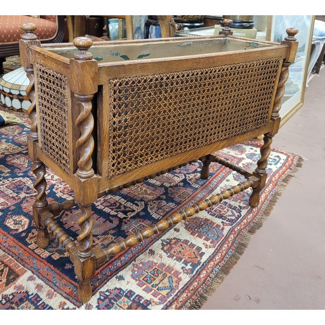 Fine antique Jacobean cane and oak indoor planter. Features barley twist frame, cane sides, metal insert with wear, and...