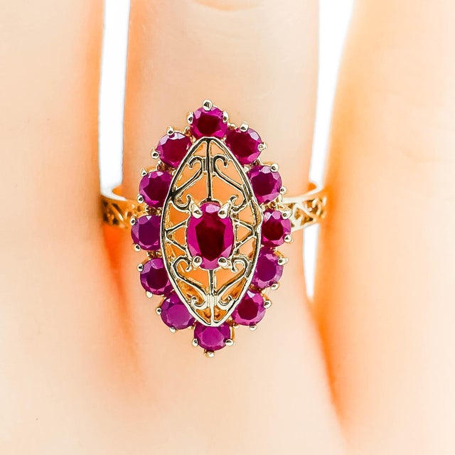 This Vintage 14K Yellow Gold Ruby Ring in Size 8 has a tapered shank that features an openwork scroll motif, connected to...