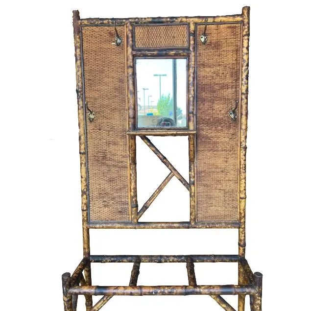 Victorian bamboo hall tree with mirror. Features 4 coat hooks and openings for umbrellas, walking canes or other...