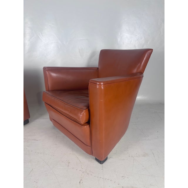 Superb pair of vintage club chairs in Havana-colored leather. Rare: small size but great comfort. Blackened wood legs. In...
