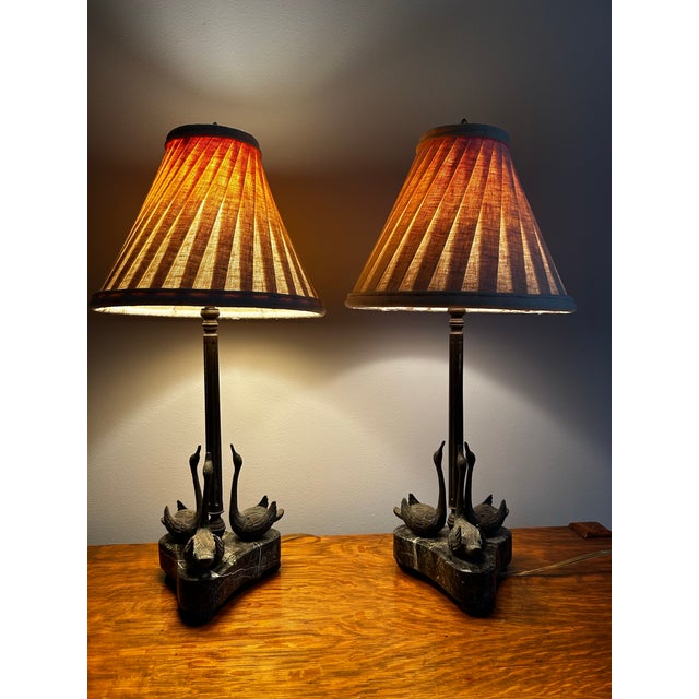 Beautiful vintage pair of bronze swan table lamps on marble bases by Theodore Alexander. Each lamp features three swans...