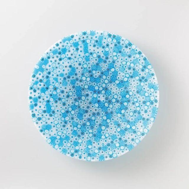 Murano glass plate made by melting together sections of glass rods in a furnace, with each section depicting a small...