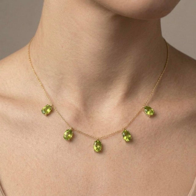 Delicate, radiant, and effortlessly elegant, this Peridot Dangle Station Necklace features five beautifully faceted oval-...