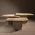 A striking set of three nesting tables crafted from solid travertine in a light, sandy hue. The minimalist 1970s design...