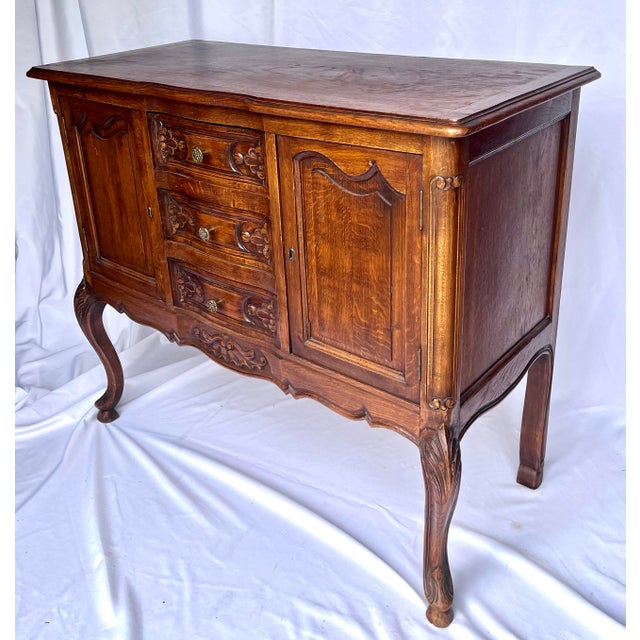 Imported from France. Louis XV style oak sideboard. This beautifully carved buffet features cabriole legs, two cabinets...