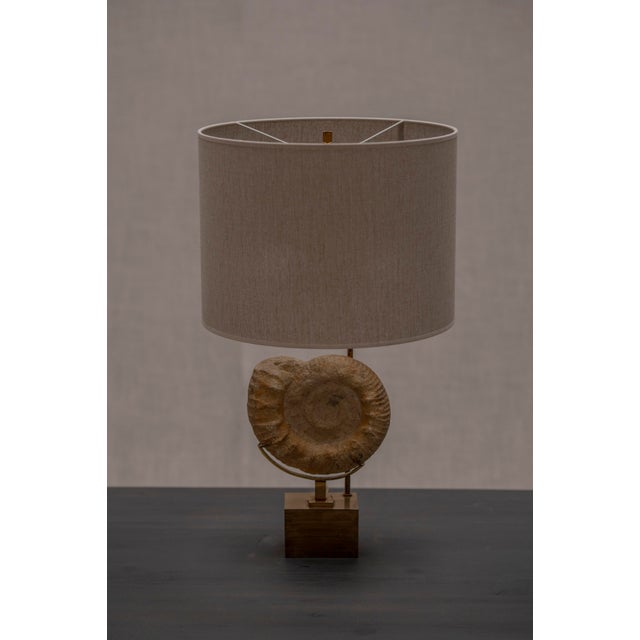 Stunning French Hollywood Regency table lamp, 1970s. Crafted in gilded brass, this striking table lamp features a...