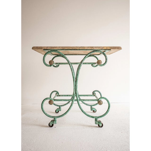 Late 19th c. French iron pastry or patisserie table, with original travertine top. The removable travertine top sits on a...