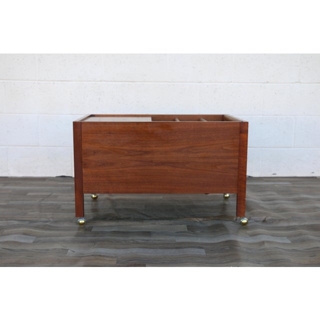 A distinctive Mid-Century Modern walnut coffee table, circa 1960s, combining beautiful craftsmanship with clever...