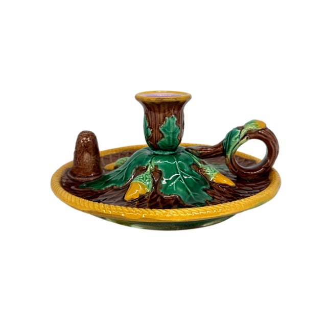A George Jones Majolica Candlestick Stand on a rustic brown ground, the stand with a comb design and raised candle snuffer...