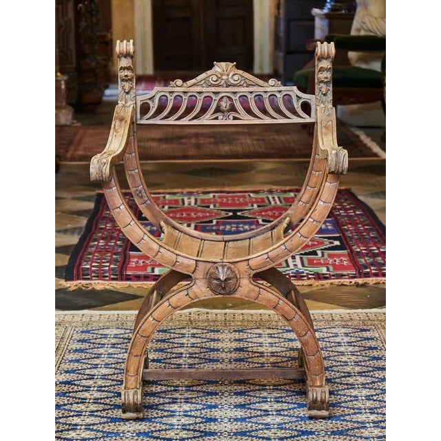 Armchair made of solid walnut decorated with hand-carved Mascaras, acanthus leaves and a large scale pattern. Scissor...