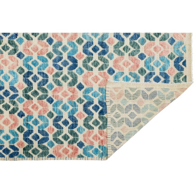 This vibrant Modern Tulu Style rug features a rhythmic, interlocking geometric pattern inspired by mid-century aesthetics...