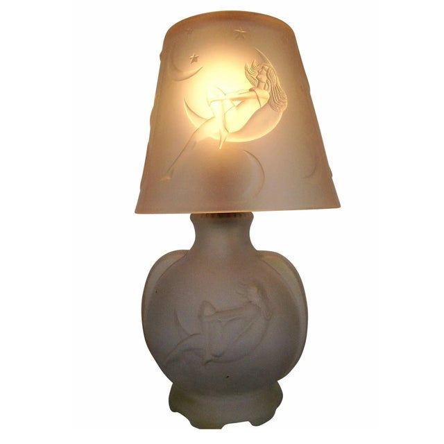 This frosted glass boudoir lamp features a nude woman gazing at the stars inside a crescent moon, made circa 1920. This...