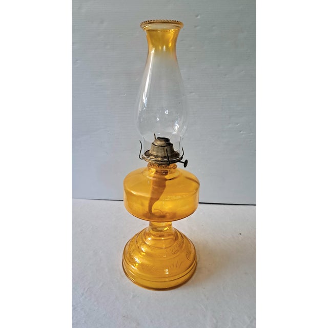 A beautiful vintage amber glass kerosene oil lamp with a traditional Early American / Edwardian-inspired silhouette. The...