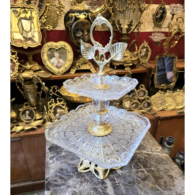 This ornate brass and crystal pedestal tray is designed to elevate refined table styling and elegant entertaining....