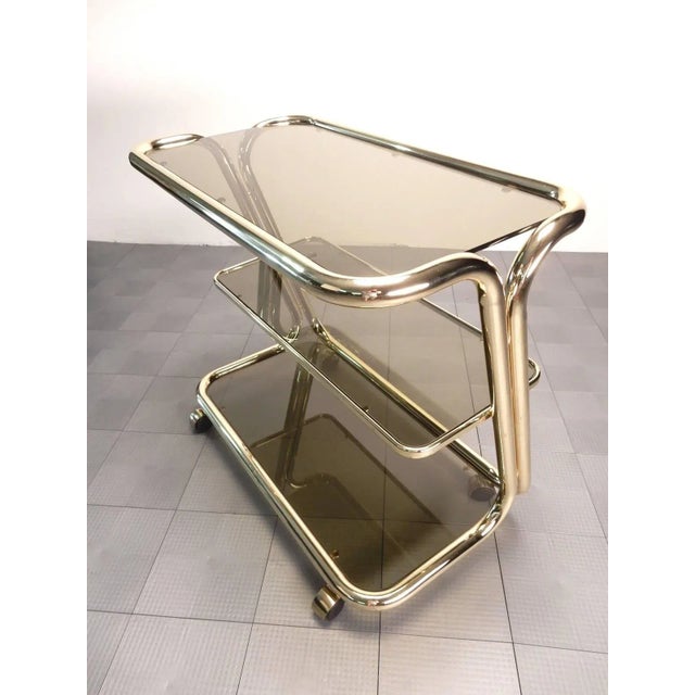 Exceptional three-tier rolling bar service cart by Italian maker Morex. Smoke glass shelving contrast on sculpted brass...